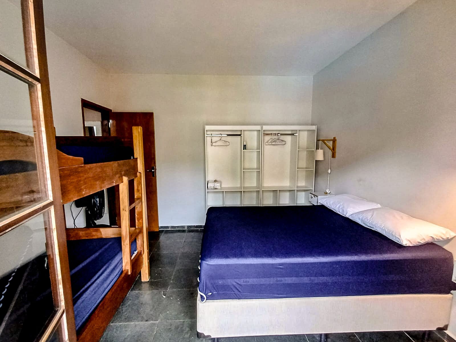 Dormitório com cama de casal e beliche no duplex do Saco da Ribeira