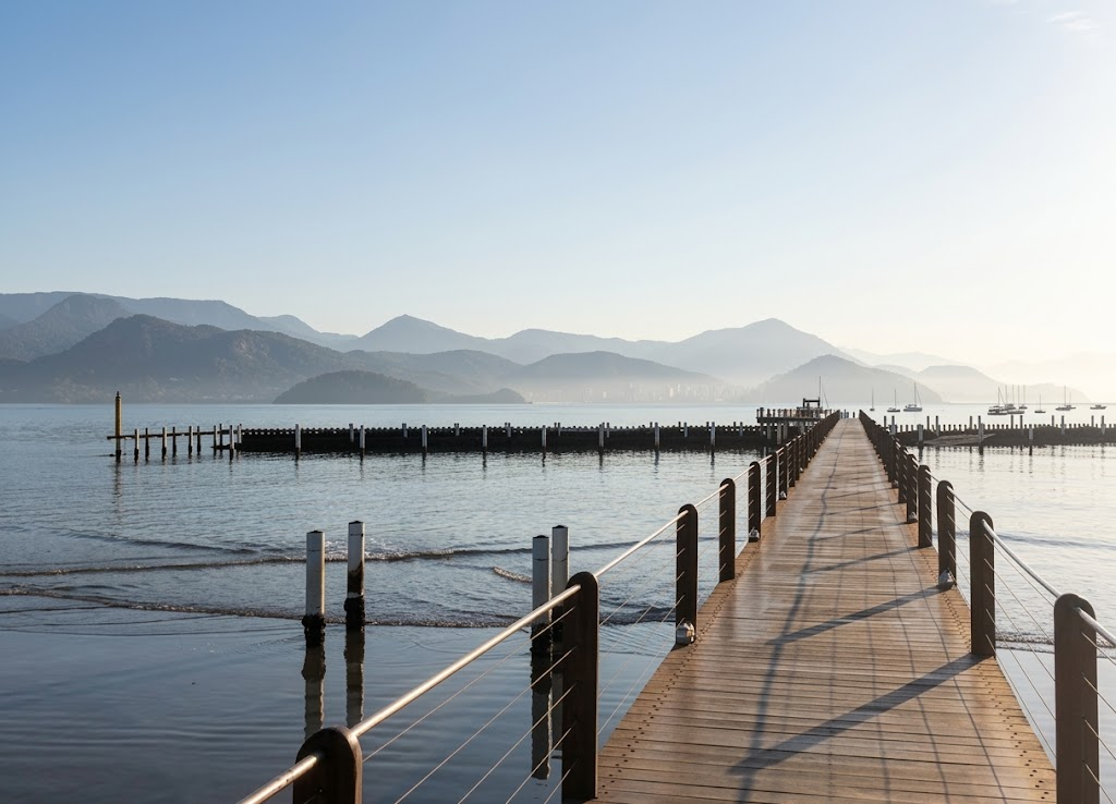 Píer de Ubatuba ao amanhecer, com a Serra do Mar ao fundo e mar calmo