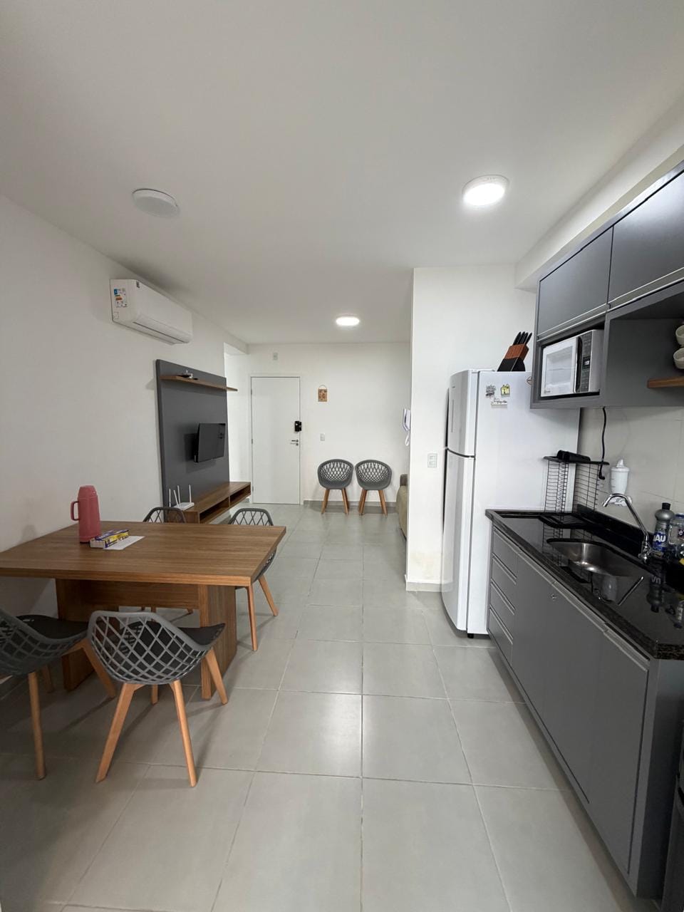 Sala e cozinha planejada conjugadas, com mesa de jantar e ar-condicionado