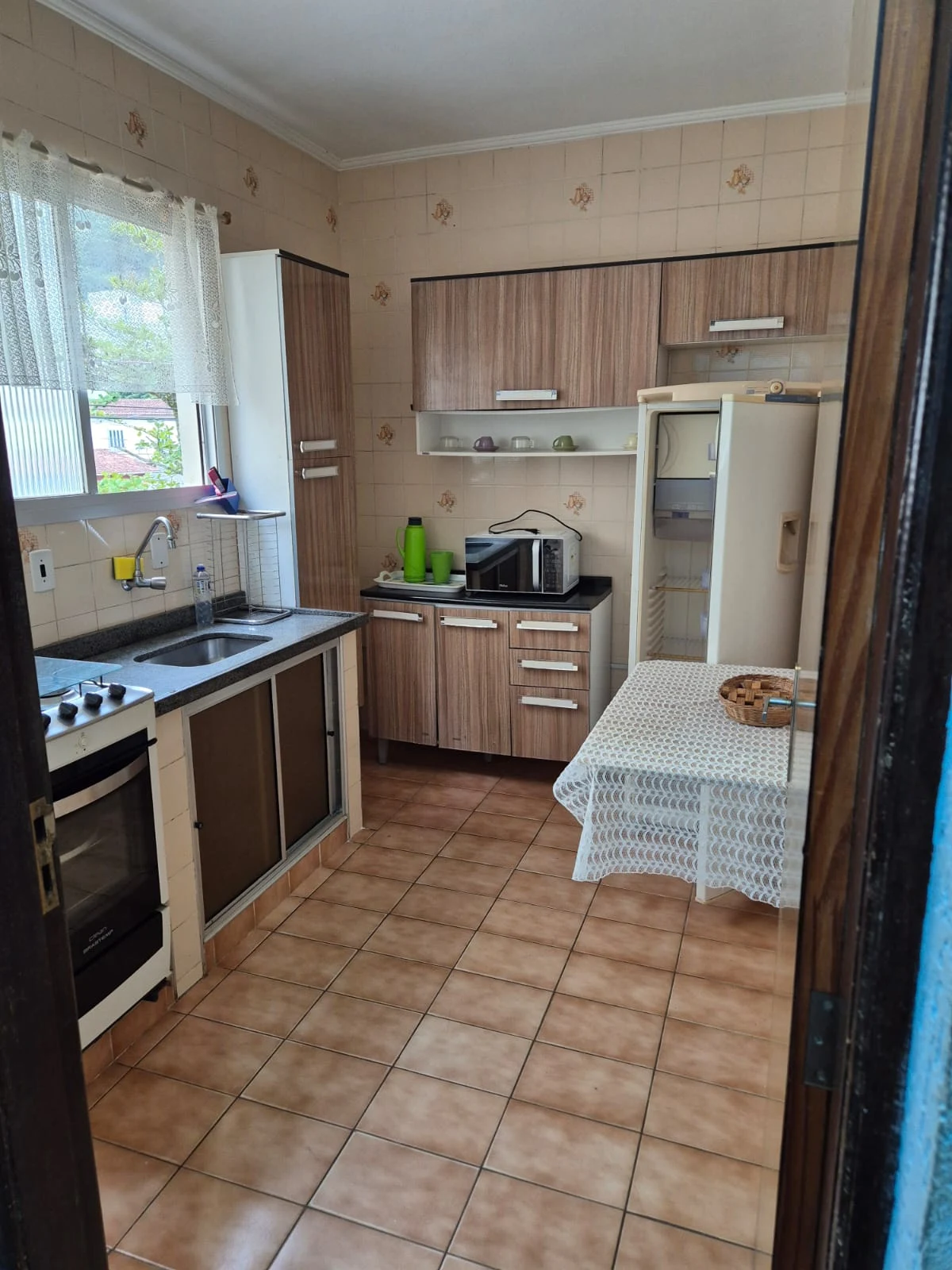Cozinha com armários, bancada e janela, apartamento na Praia Grande
