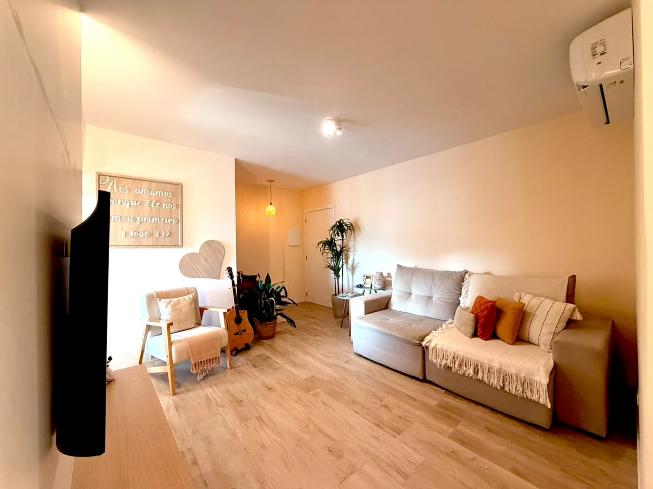 Sala de estar com sofá, televisão e ar condicionado