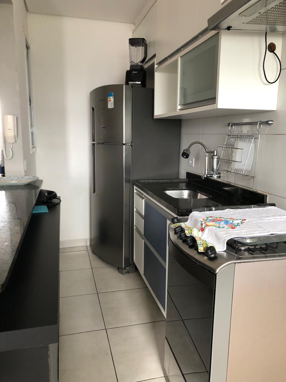 Segundo ângulo da cozinha com armários, apartamento mobiliado no Estufa I, Ubatuba