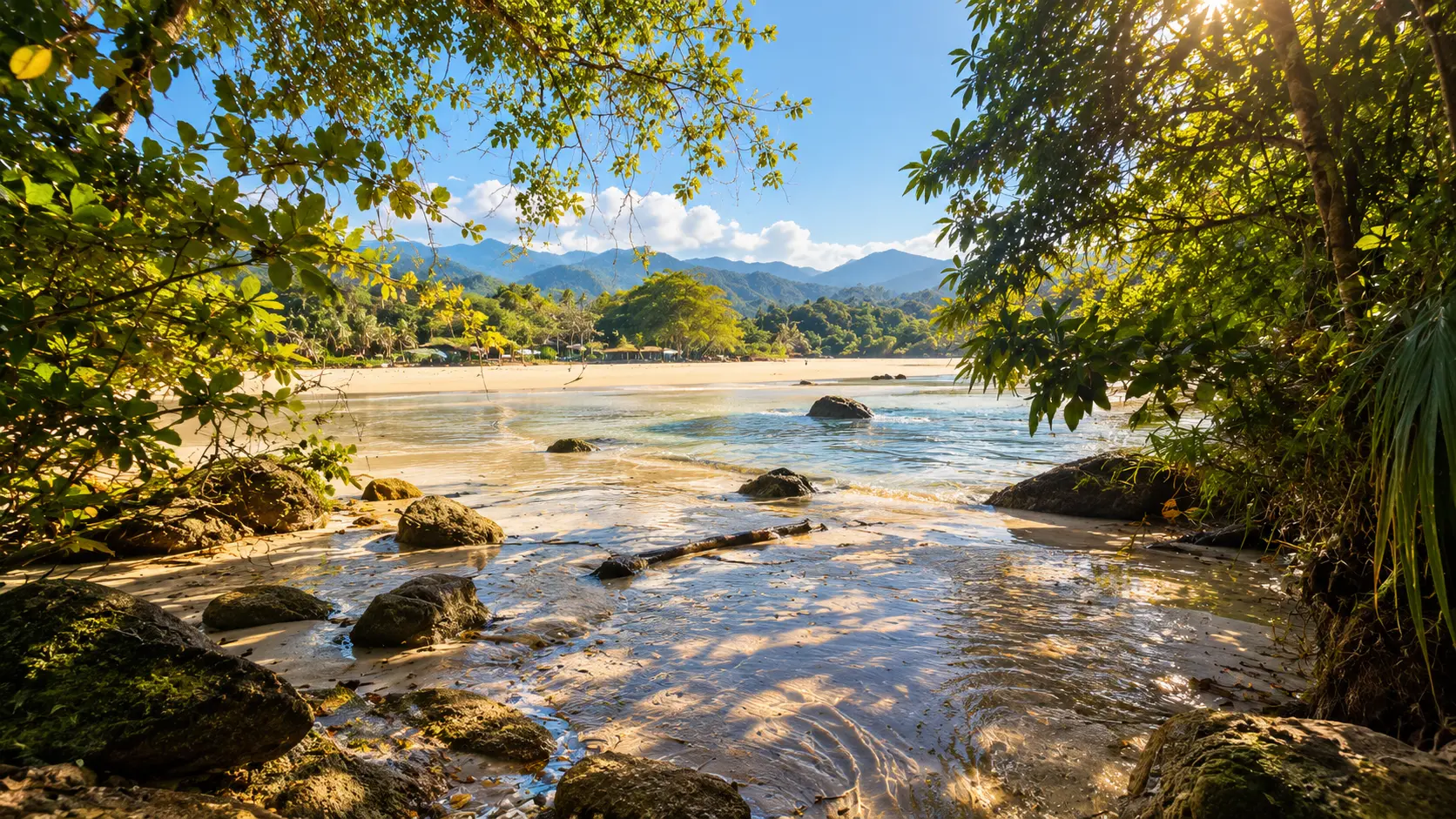 Praia da Lagoinha com mar calmo, areia dourada e montanhas ao fundo, vista natural emoldurada pela vegetação, Ubatuba