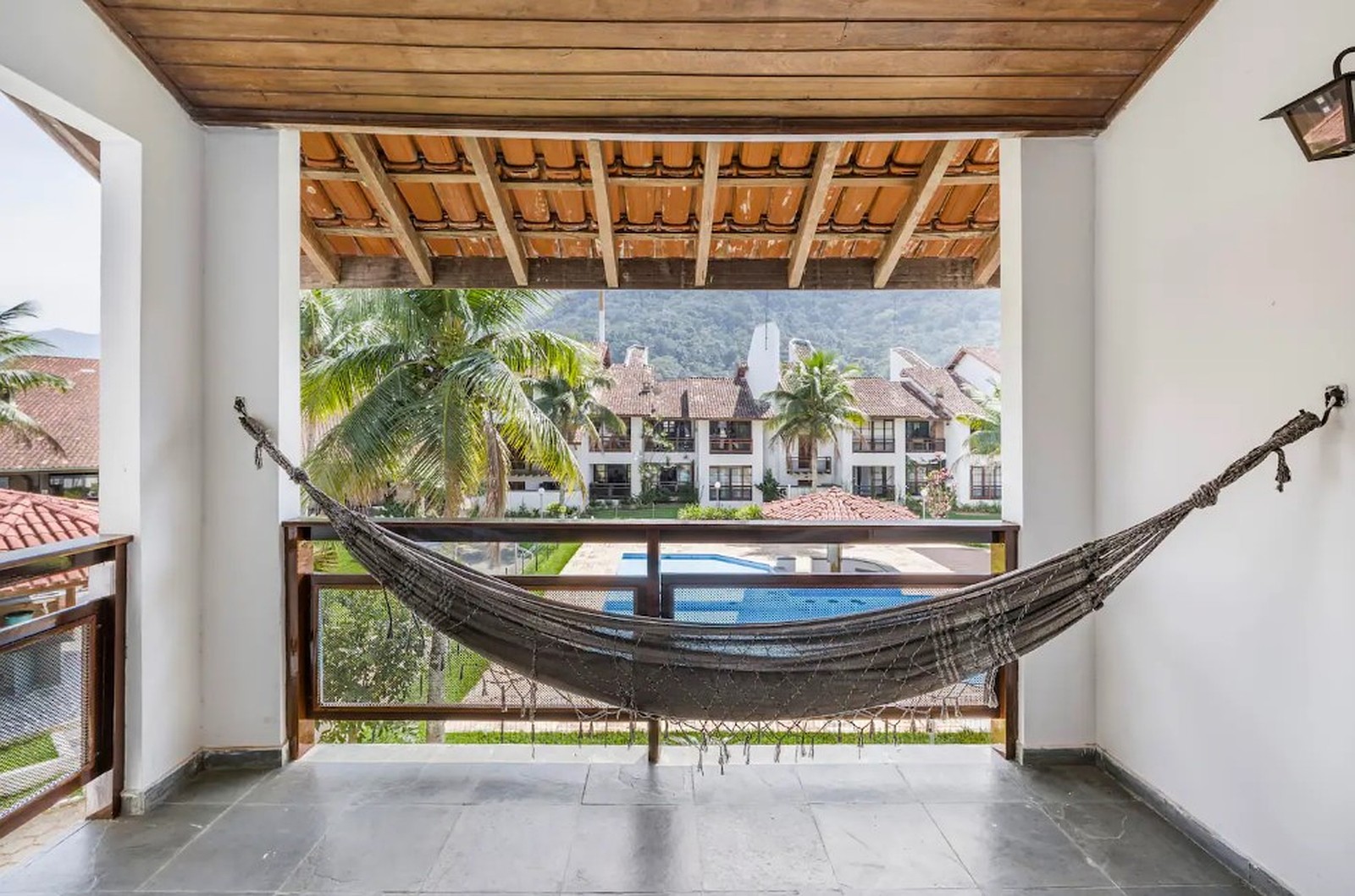 Varanda com rede e vista para a piscina do condomínio no Saco da Ribeira