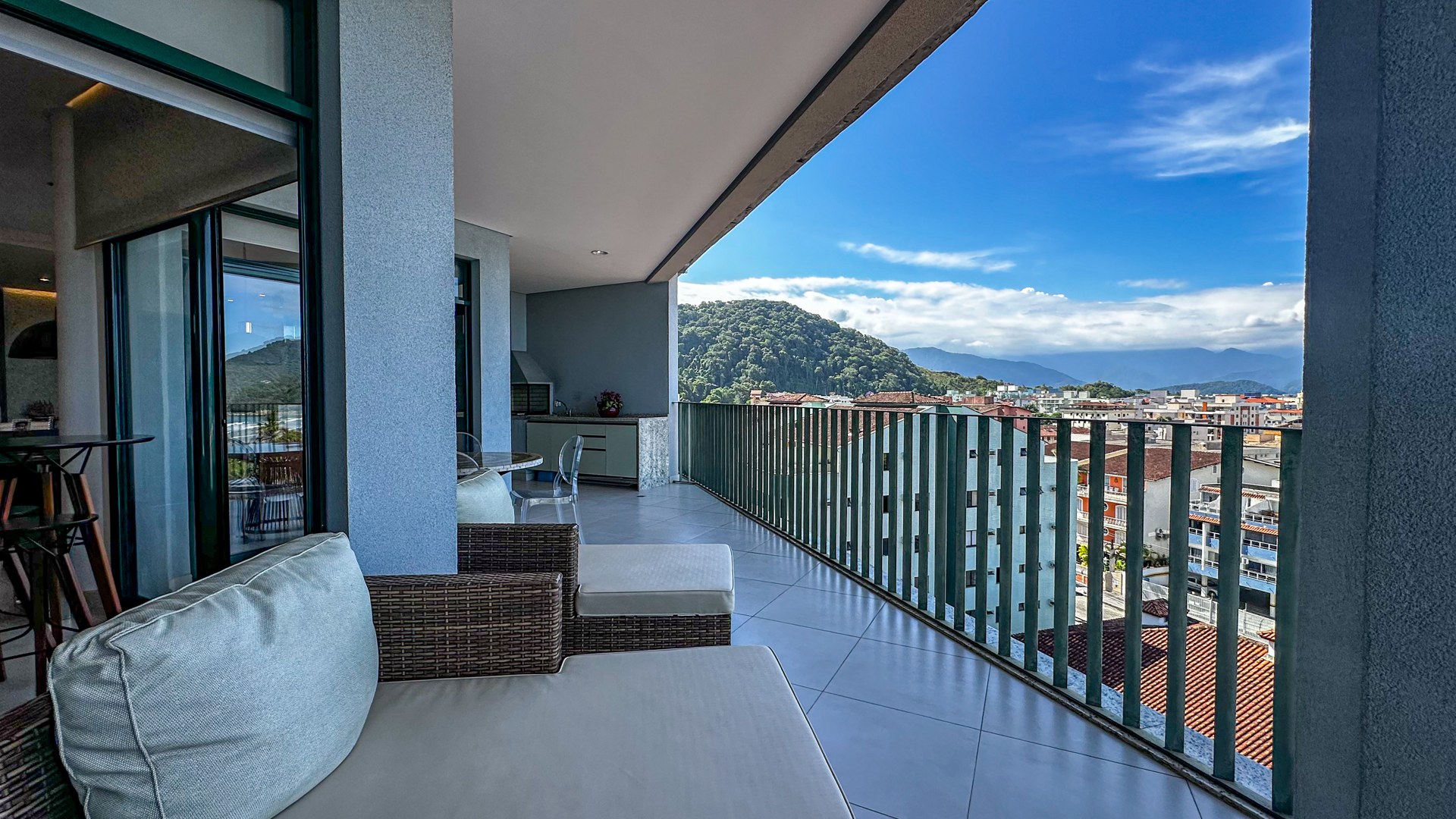 Varanda lounge com sofá e vista para o mar e a Serra do Mar