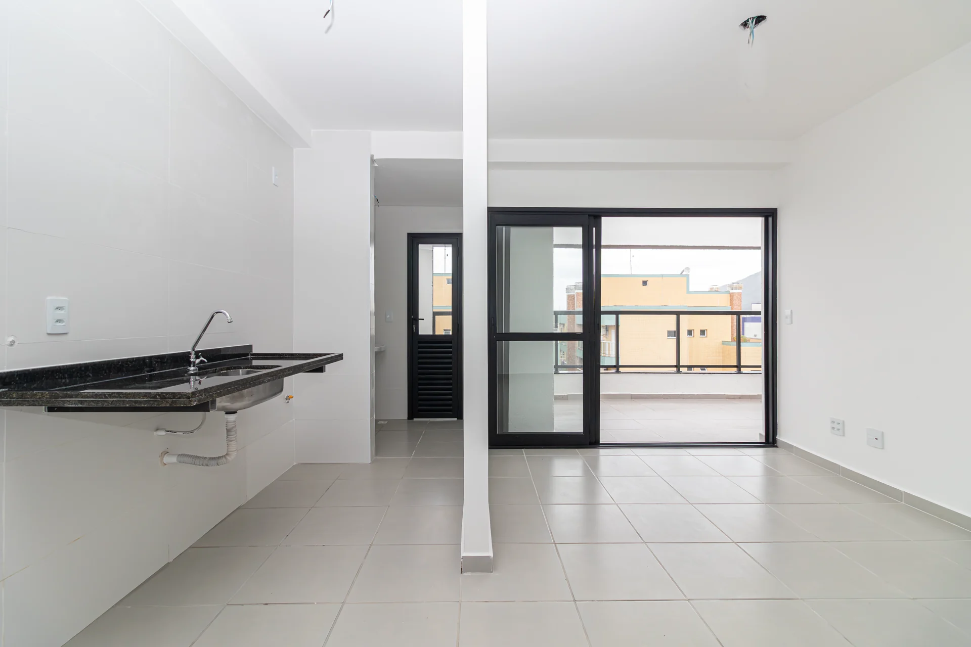 Sala ampla da cobertura com porta de correr para a varanda gourmet, Alpha Haus, Itaguá