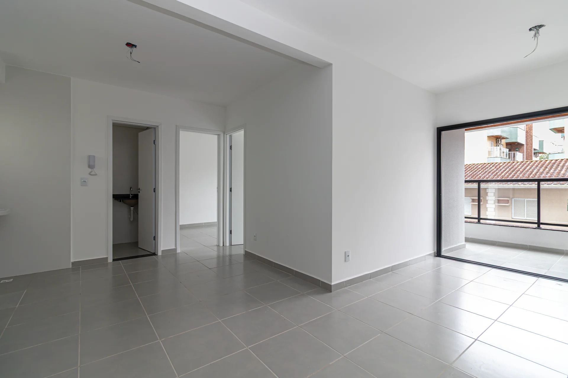 Sala ampla do apartamento novo com acesso à varanda e circulação para os dormitórios