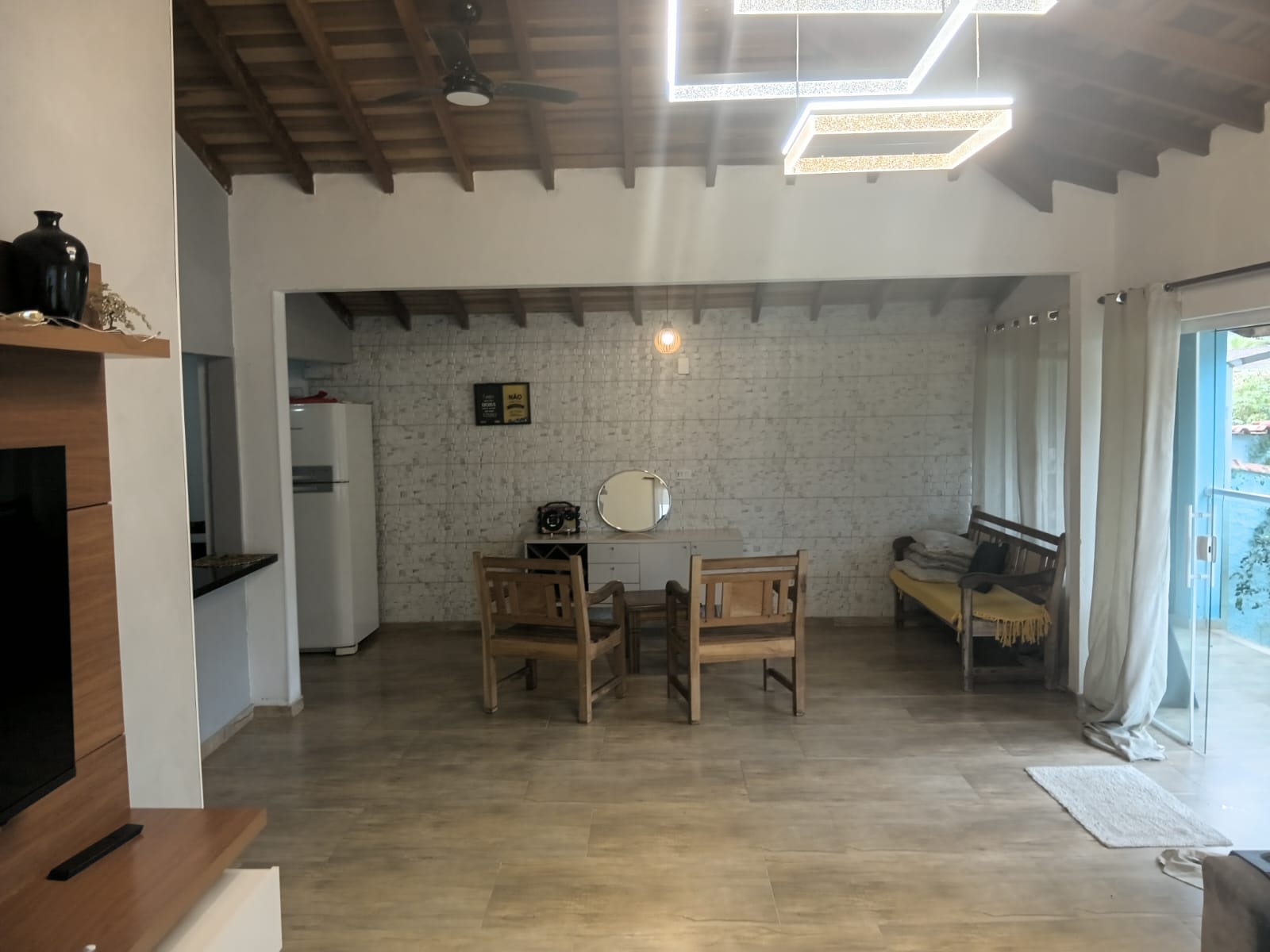 Sala de jantar integrada com pé-direito alto e iluminação contemporânea, casa térrea com piscina na Lagoinha, Ubatuba
