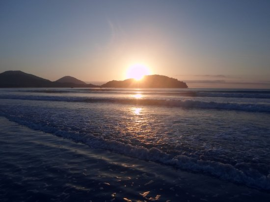 Sol sobre o mar protegido pelas montanhas