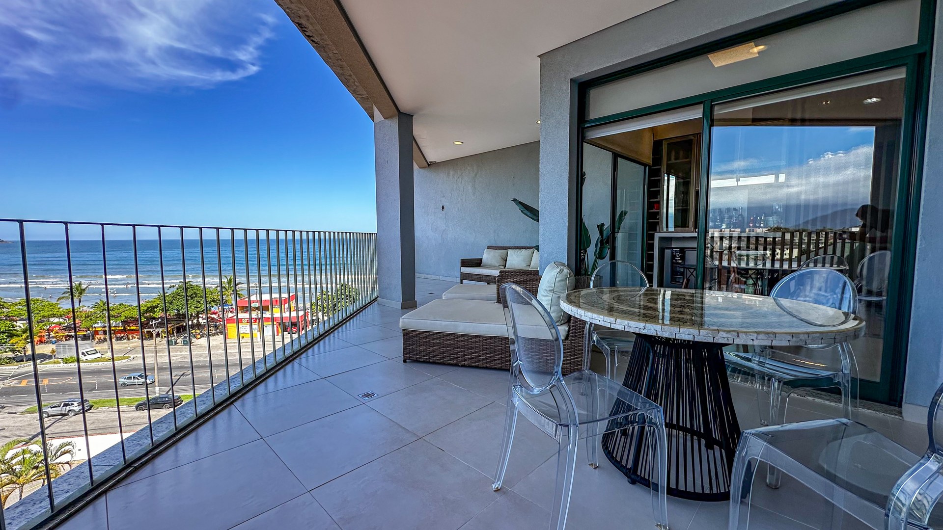 Varanda com mesa de jantar e vista para a orla da Praia Grande