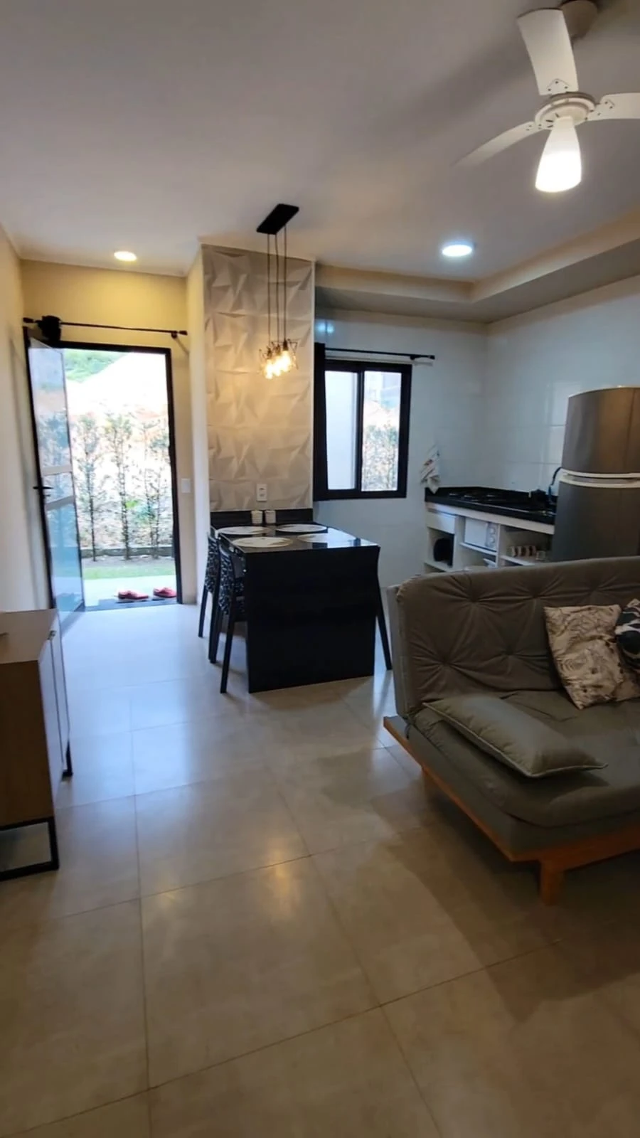 Sala mobiliada integrada à cozinha e área de jantar do apartamento no SAMOLA